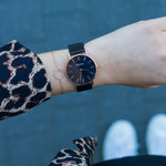 elysian-rose-gouden-dames-horloge-zwart-plaat-zwart-mesh-horlogeband-ELY01110-hand